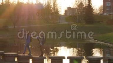 在日落时分，一家人带着孩子经过一座美丽的桥。 阳光照在镜框里